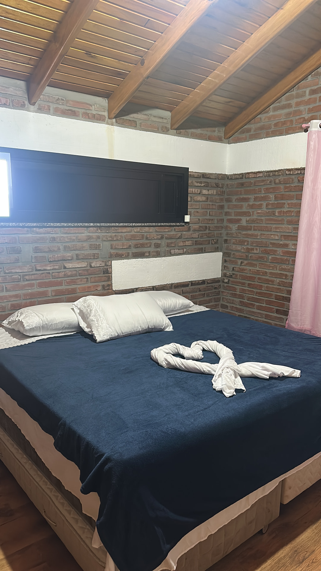 Quarto com paredes de tijolo e cama de casal